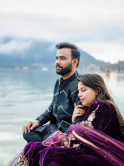 A serene and majestic shot of the couple on a Shikara boat in Dal Lake, Kashmir. The misty mountains in the background add a sense of peace and grandeur to this destination pre-wedding photo.