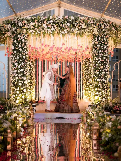 A monsoon wedding that feels like a movie. The mirrored aisle reflecting the stunning floral mandap inside the clear-top tent was a detail that made the backup plan feel like the main event.