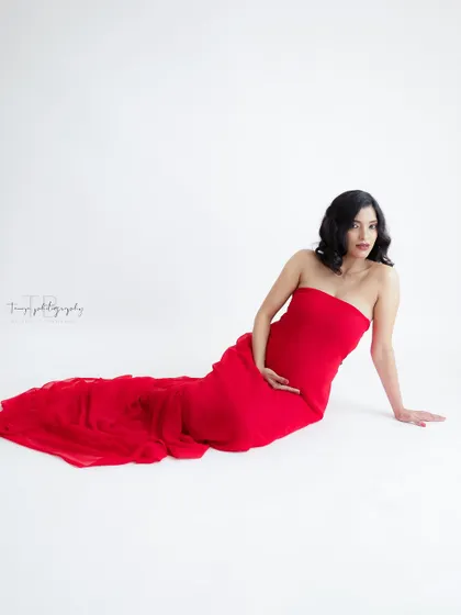 A duplicate of image 202, this simple and elegant portrait in a flowing red gown against a white background is striking and beautiful.