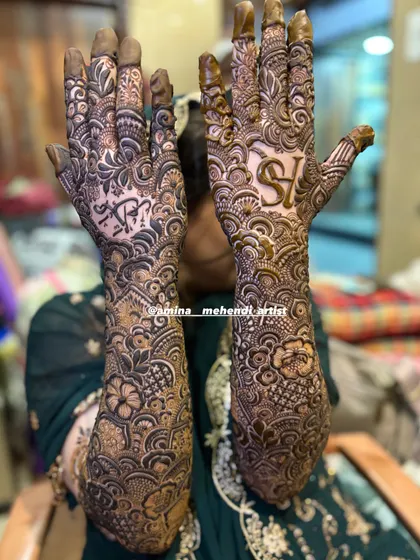 This design features the initials 'S' and 'H' and a name in Arabic script, surrounded by dense floral work.