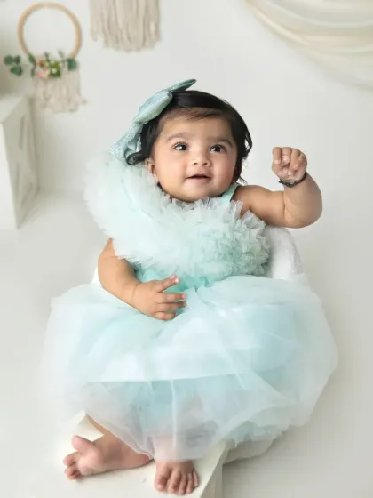 A sweet, happy expression from this little girl in her pretty dress. The simple, bright setup is perfect for timeless infant portraits.