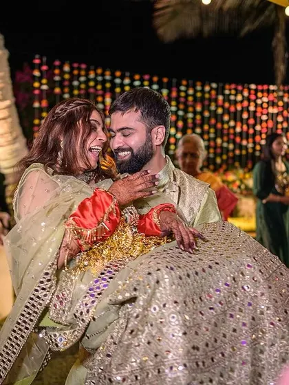 The groom lifting his bride in a joyful, spontaneous moment on the dance floor at their Goa reception.