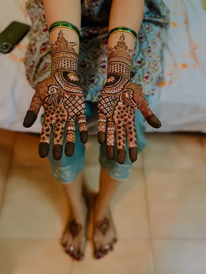 A full bridal look with matching intricate designs on both hands and simple, elegant mandalas on the feet.