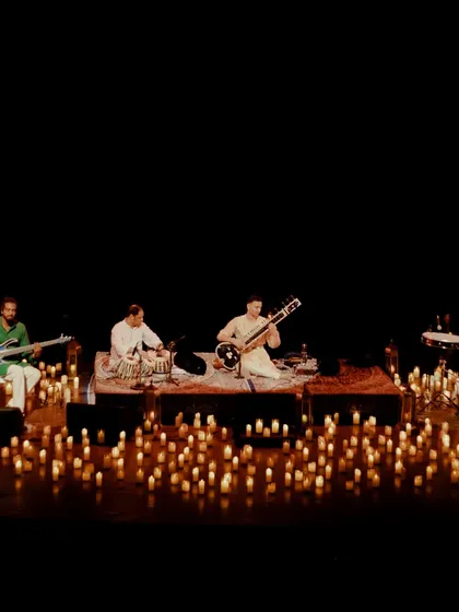The full band setup surrounded by candles, creating a rich, layered sound that is still deeply meditative and personal.