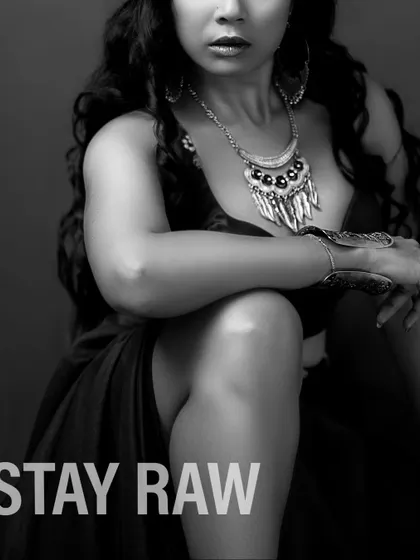 A black and white, stylized shot of the green lehenga set, with the text "STAY RAW" to emphasize a modern, unfiltered attitude.