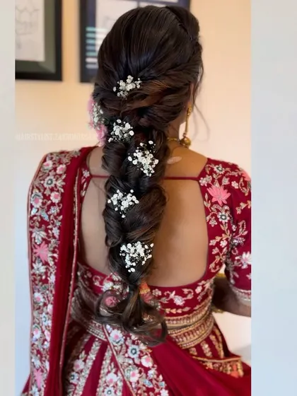 A beautiful fishtail braid with baby's breath woven through it. This is a classic and romantic choice for a bride who wants a soft and elegant look.