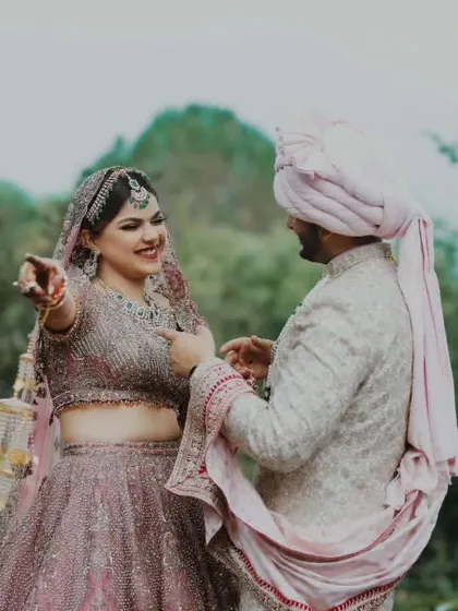A playful, candid moment from a destination wedding in Bhimtal. The bride's joyful expression and natural interaction show that even on the wedding day, we can capture the fun and spontaneity of your relationship.