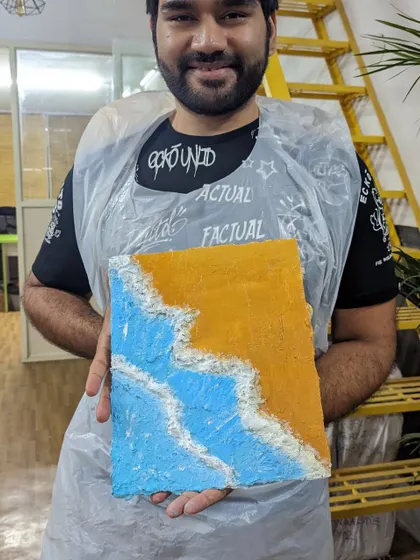 A participant with his finished beach texture painting. The texture paste gives the sand and waves a realistic, 3D feel.
