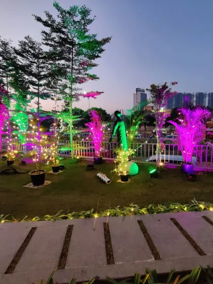 Our expertise in lighting can transform any outdoor space. Here, we used a combination of pink and green uplighting on trees and fairy lights to create a vibrant, modern party atmosphere for a Christmas celebration.