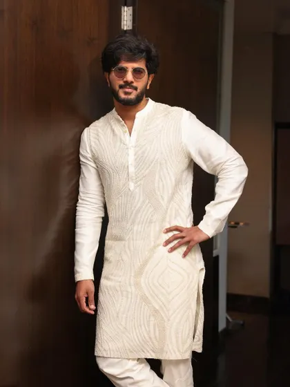 Dulquer Salmaan in a custom white embroidered kurta by Mishru. The subtle, tone-on-tone embroidery gives it a refined and luxurious feel.