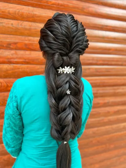 This angle highlights the beautiful floral clips that add a touch of elegance to the modern braid style.
