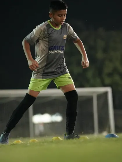 A young player focused on his footwork during a cone drill. Mastering these basics is essential for controlling the game.