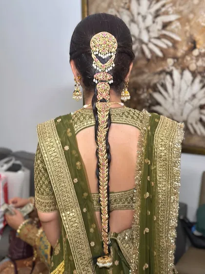 A detailed shot of the magnificent gold hair jewelry on the traditional braid, a true statement piece for a royal bridal look.