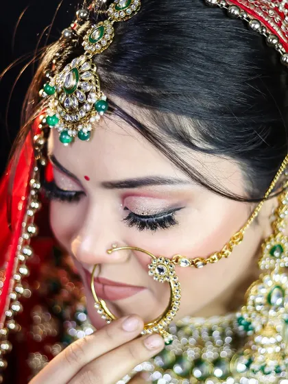 A detailed shot of the nose ring and eye makeup. Mastering the application of traditional bridal accessories is a key part of our comprehensive training.