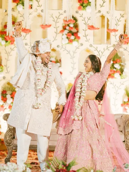 A moment of pure celebration after the Varmala ceremony. The couple's triumphant pose and joyful smiles are infectious.