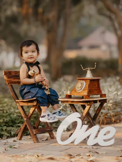 A dapper little gentleman in a bowtie poses for his first birthday photo with a vintage telephone prop.