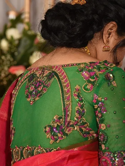 This green blouse features a unique, pot-shaped back opening, intricately embroidered along the edges to create a stunning focal point.