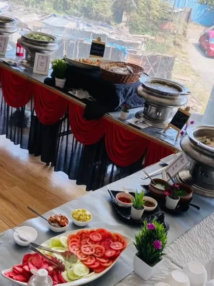 This image showcases a full buffet spread with a salad bar in the foreground. We use multi-level displays and decorative elements like plants to create a visually interesting and abundant food station.
