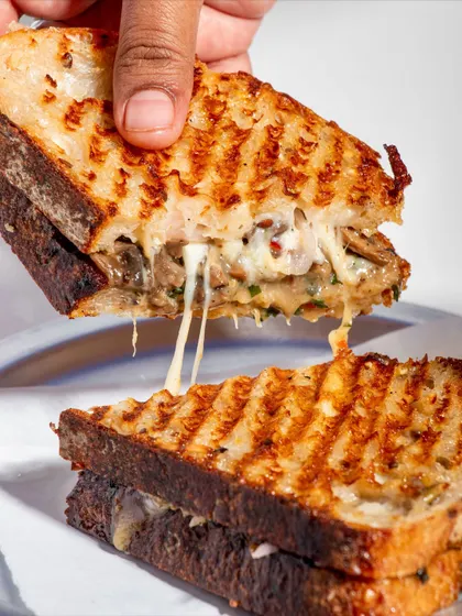 Another angle of the perfect cheese pull on the Cheesy Mushroom Melt.
