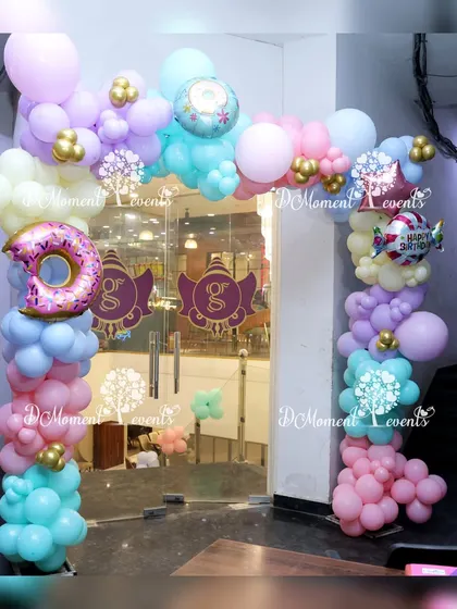 A donut-themed balloon arch welcomes guests to a sweet celebration.