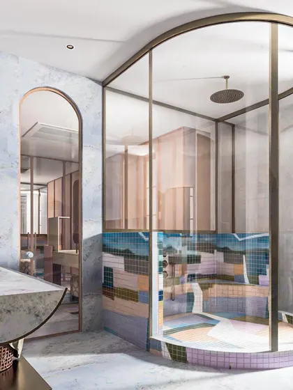 Another perspective of the master bathroom, showing the play of light and reflection on the curved glass of the shower and the mosaic tiles.