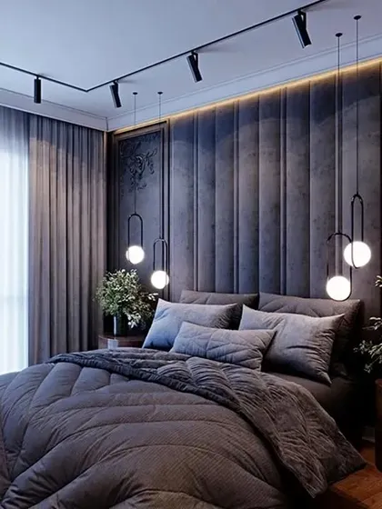 We created a moody and dramatic ambiance in this bedroom with a dark, vertically padded accent wall and track lighting. The simple bedding and sheer curtains balance the bold design.