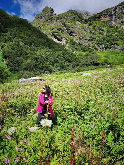 Another shot from the Valley of Flowers, this time with the pink jacket fully on, showing a practical and vibrant trekking look.