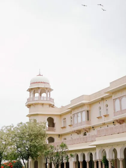 The stunning architecture of a palace in Jaipur, with birds taking flight. This image captures the serene and timeless beauty of India's heritage.