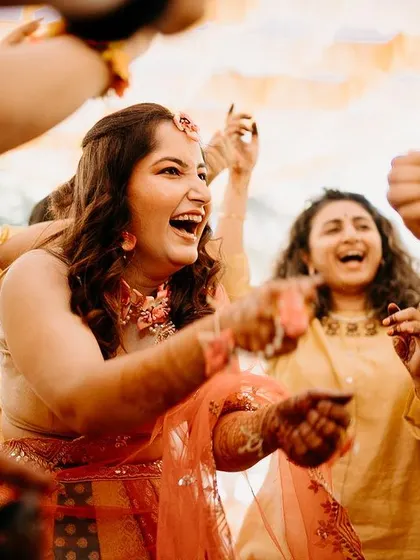 The bride is surrounded by her dancing friends, her face lit up with a huge smile.