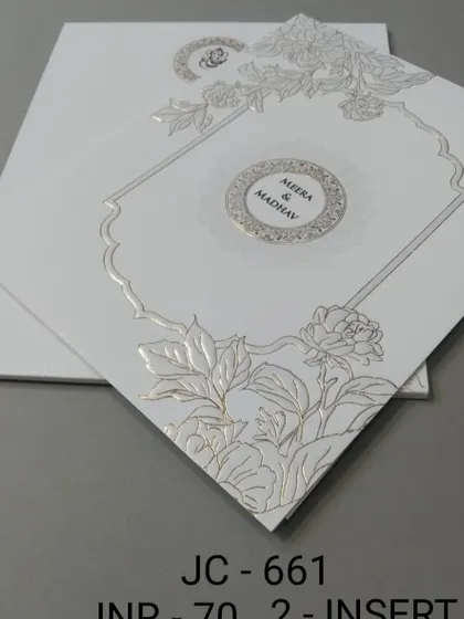 A clean white invitation with a silver foil floral design and a central monogram. The look is modern, elegant, and perfect for a sophisticated couple.