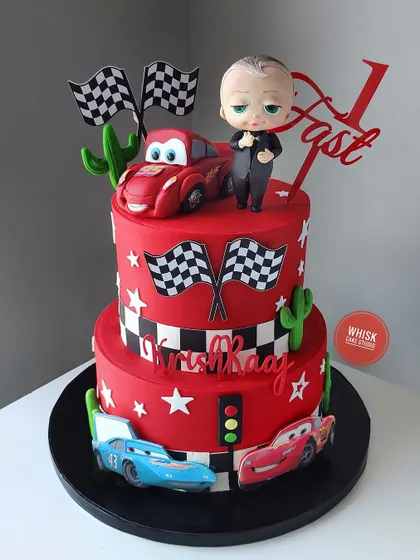 The Boss Baby meets Cars in this fun crossover cake. This two-tiered red cake is perfect for a "Two Fast" birthday party, featuring Lightning McQueen and a handcrafted Boss Baby.