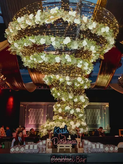 The flower tornado. One of my signature statement installations, this piece was designed to be the dramatic centerpiece of a cocktail bar. It’s a whirlwind of florals and fairy lights, engineered to draw the eye and create an unforgettable focal point that guests talk about long after the party ends.