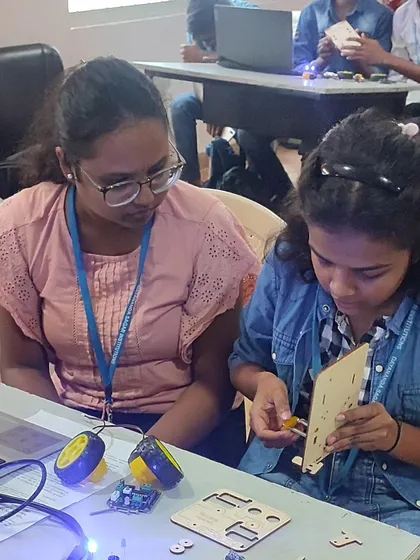 Two students collaborate on assembling their robot, a common sight in our workshops where peer learning and teamwork are highly encouraged.