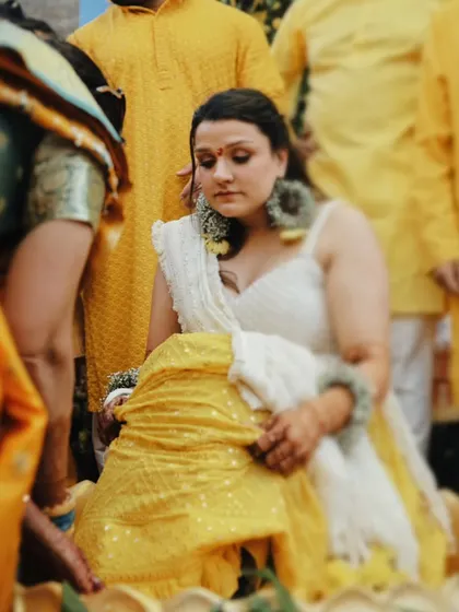 A quiet, candid moment of the bride during her Haldi ceremony, surrounded by the vibrant yellow theme.