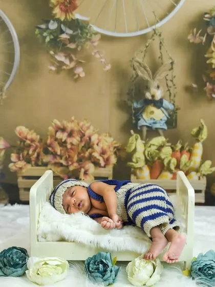 A sleepy bunny in his little bed. Our themed newborn setups, like this rustic rabbit theme, add a touch of whimsy to your baby's first portraits.