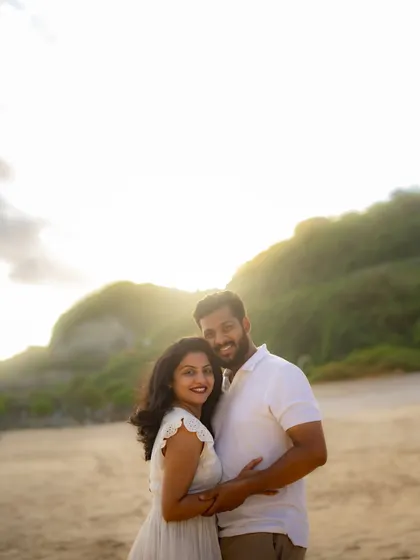 A happy couple portrait taken during the golden hour at a beach destination. The warm sunlight beautifully highlights their joy and the stunning natural surroundings.