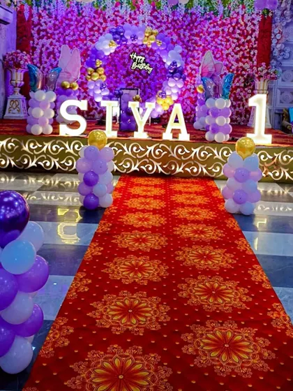 The view from the entrance down the red carpet to the main stage, showing the cohesive purple-themed decoration.