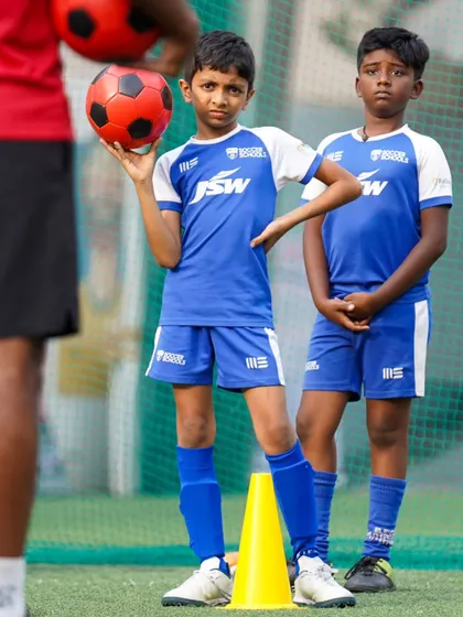 There is no learning without fun. A young player holds the ball with a confident pose, ready for the next drill.