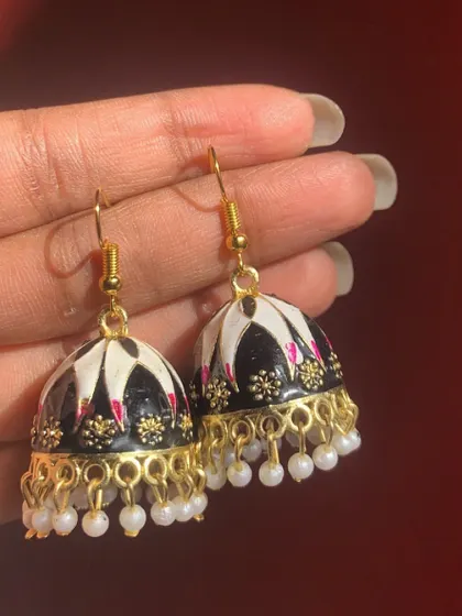 Another view of the popular black and white Meenakari hook jhumkas. The detailed painting and pearl accents make them a truly special piece.
