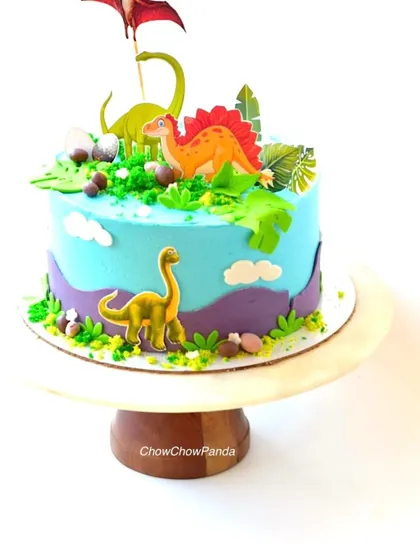 A closer view of the dino cake, showing the different types of dinosaurs and the textured green buttercream details.