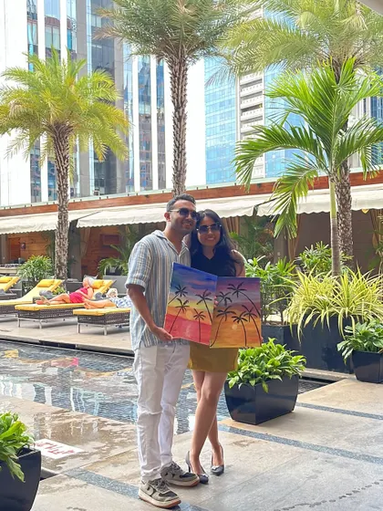 The happy couple showing off their finished masterpiece at their engagement party. A joint canvas painting is a great way for couples to collaborate and create a lasting memory of their special day.
