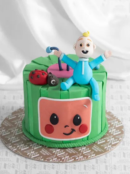 It's Cocomelon time! This vibrant green cake brings the beloved children's show to life with its iconic watermelon design and a cheerful JJ character on top.