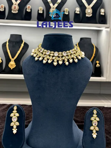 A simple yet elegant polki choker set with leaf-shaped stones and pearl drops, perfect for a minimalist bride.