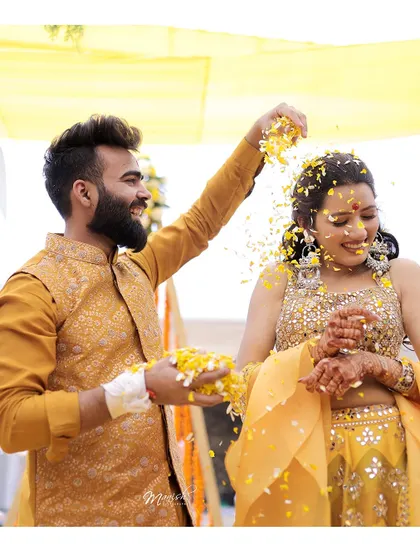 A playful moment where the groom showers the bride with flower petals, their laughter making the shot extra special.