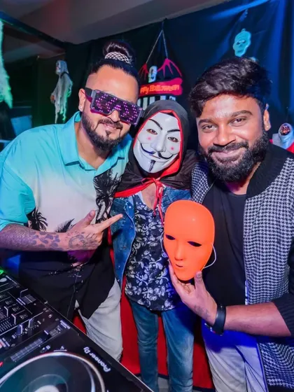Posing with guests in costume at a Halloween party.