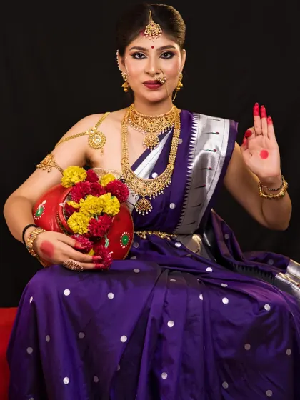 The full look of goddess Kushmanda, holding a kalash. The rich purple saree and gold jewellery create a regal and divine appearance.