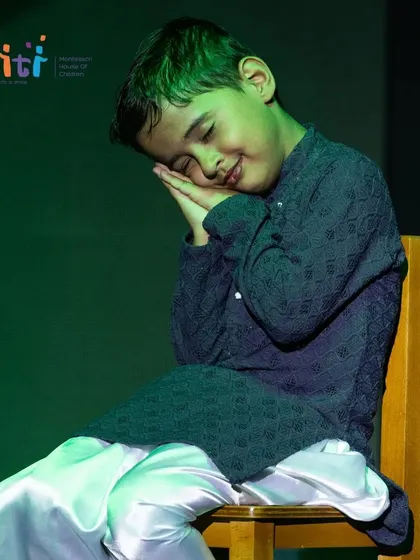A child peacefully "sleeps" on stage, part of the narrative of our "Pancha Tattva" dance drama.