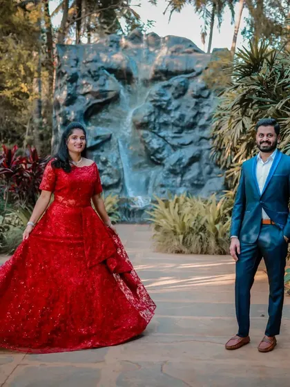 This shot shows the full elegance of the red lace gown against a garden backdrop. It's a versatile dress that works beautifully in many different settings.
