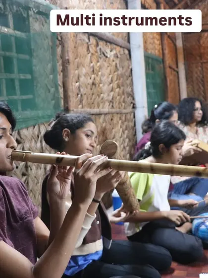 A student learns to play a large bamboo flute. We explore instruments of all shapes and sizes, each with its own unique voice and healing properties.