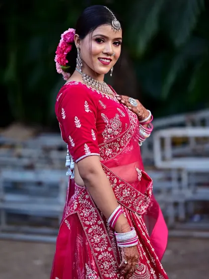 A close-up portrait highlighting the intricate silver embroidery on the blouse and the beautiful bridal makeup.